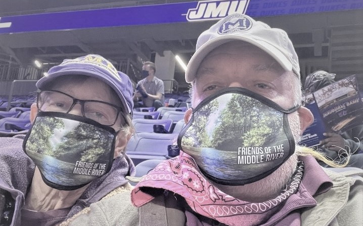 two people in stadium wearing face masks