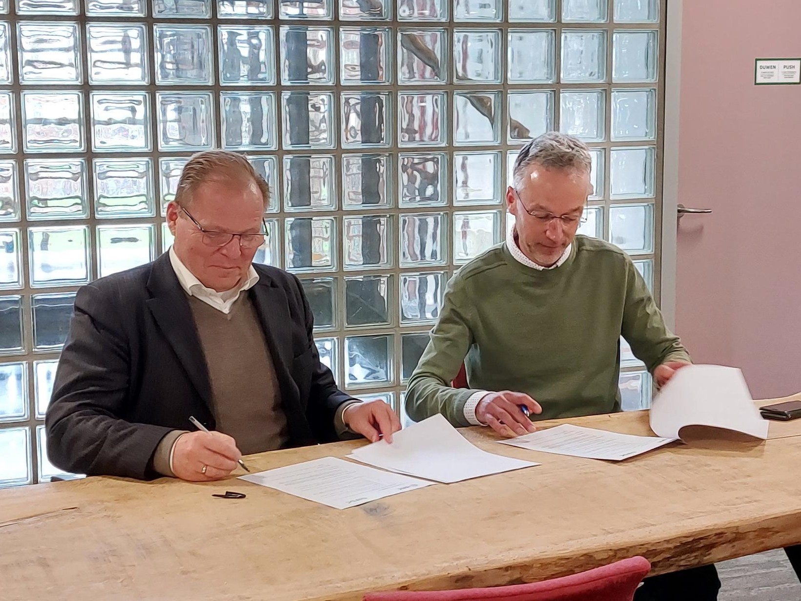 IFDC President and CEO Henk van Duijn sits next to ISRIC Director Rik van den Bosch while signing the new partnership agreement.
