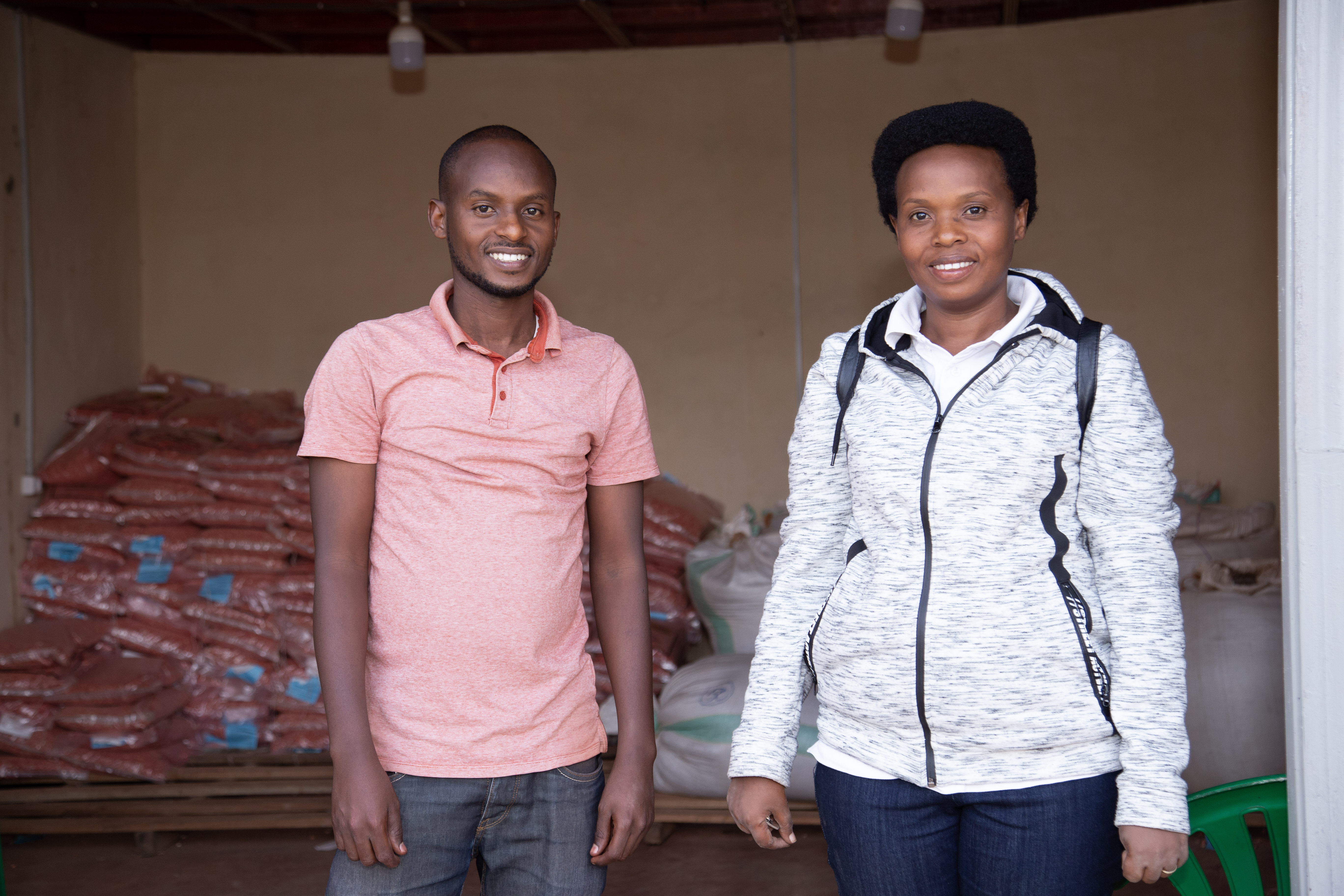 Two agriculture professionals inspect a fertilizer sample in an agro-input shop