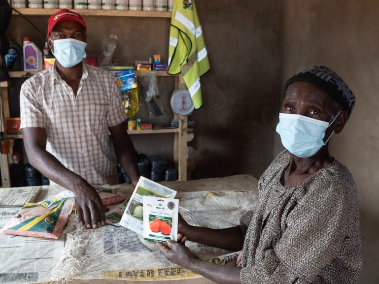 A shop worker (left) and female farmer (right) stand in a Mozambique ag input shop