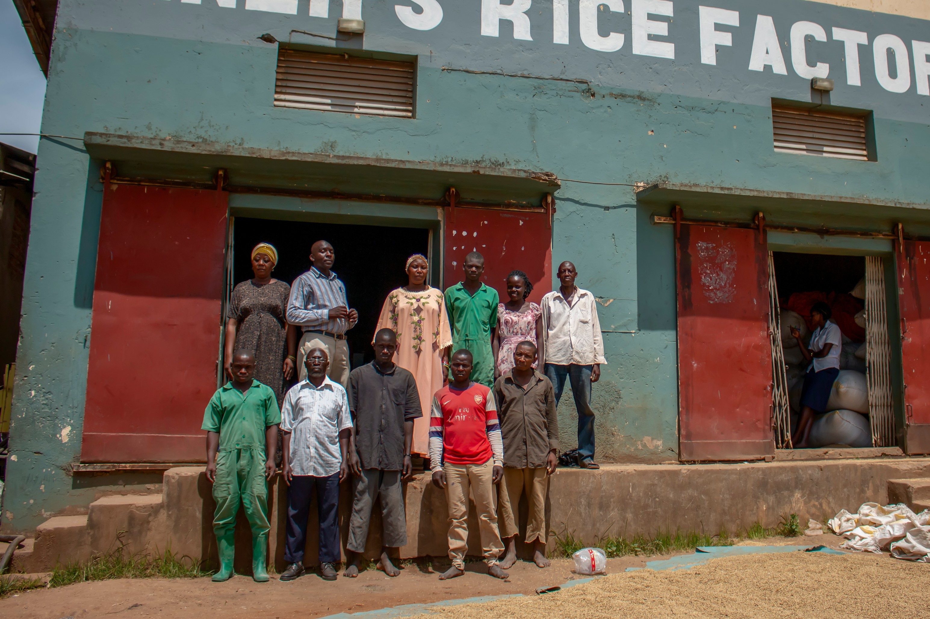 Workers stand in front of a rice factory