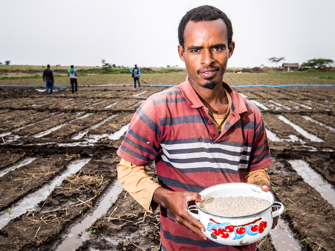 A member of the Meki Batu Fruit and Vegetable Growers Cooperative in Ethiopia stands ready to apply fertilizer to his field.