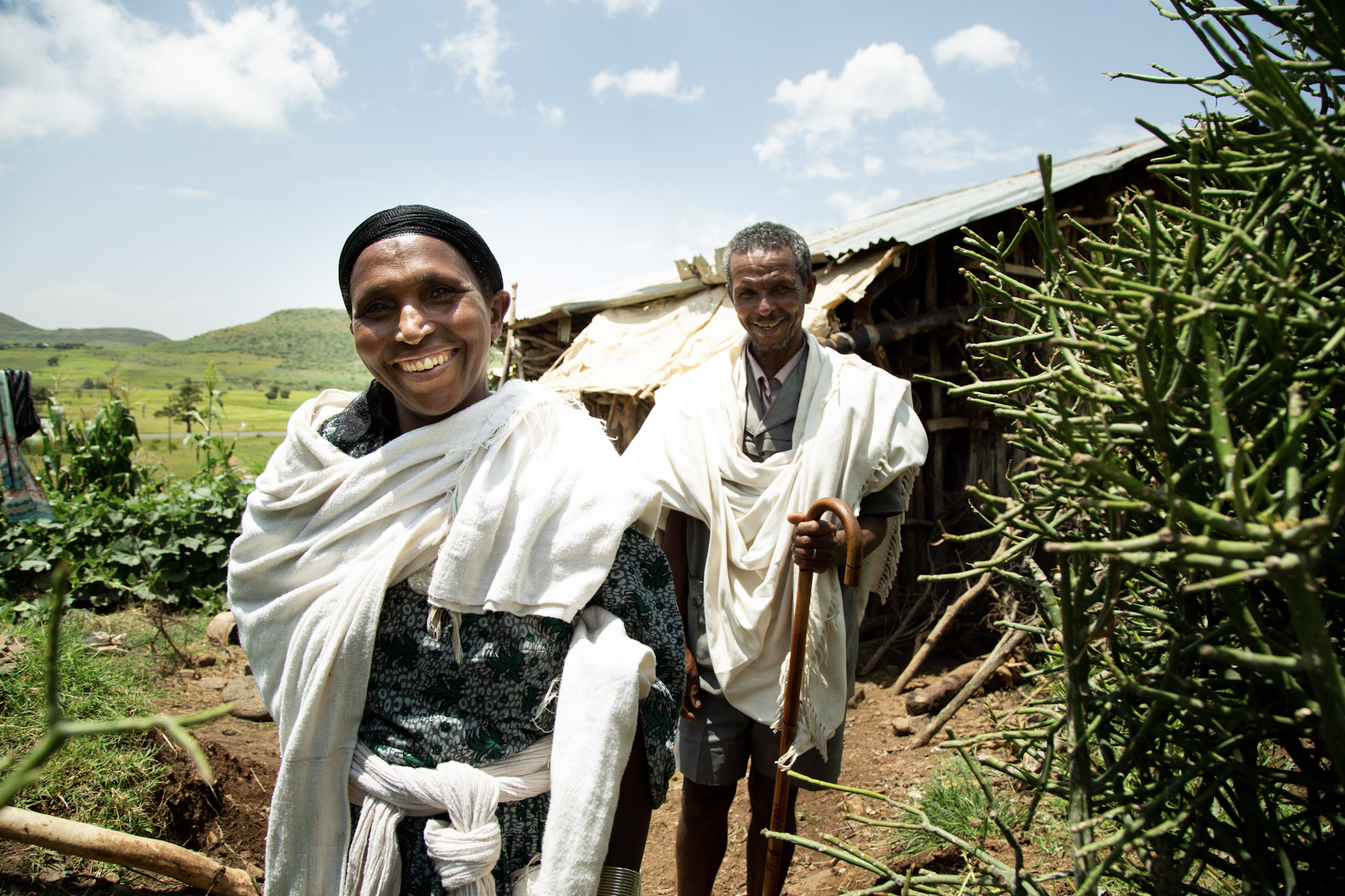 An Ethiopian couple smiles in front of a building