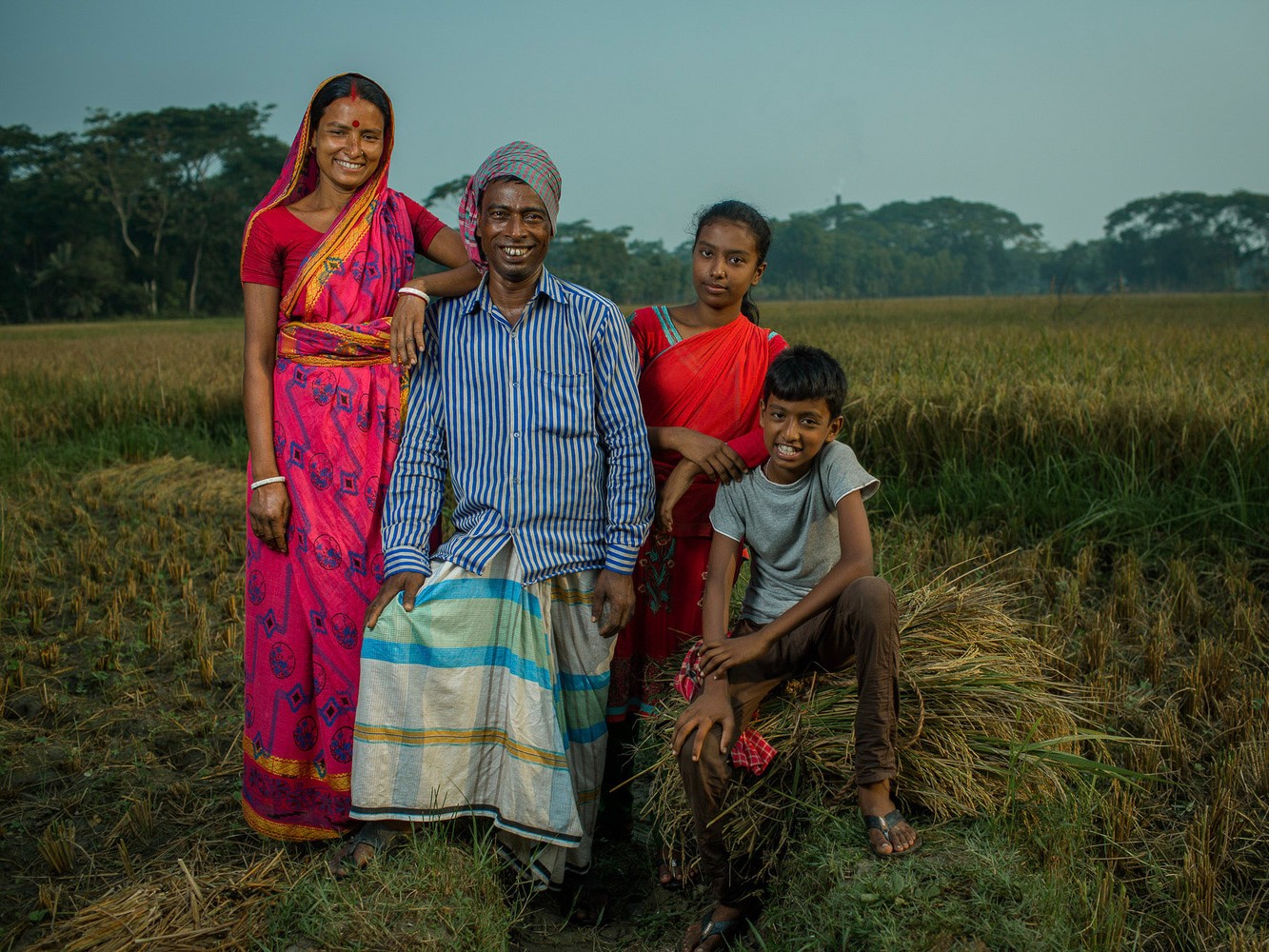 A family from Bangladesh poses in their rice field