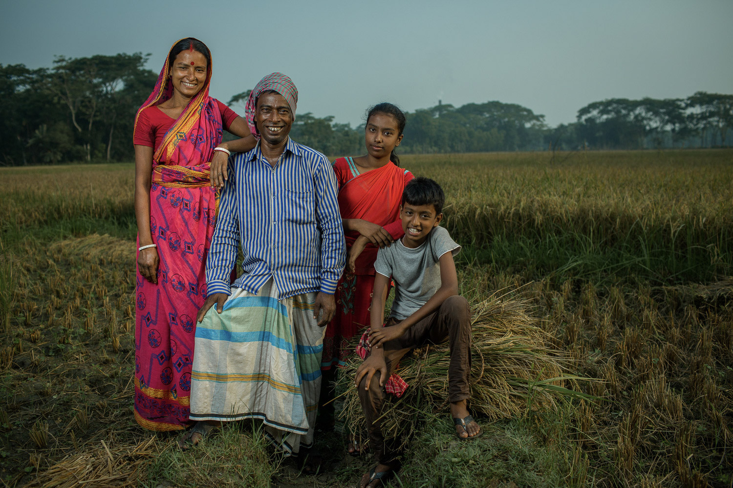A family from Bangladesh poses in their rice field
