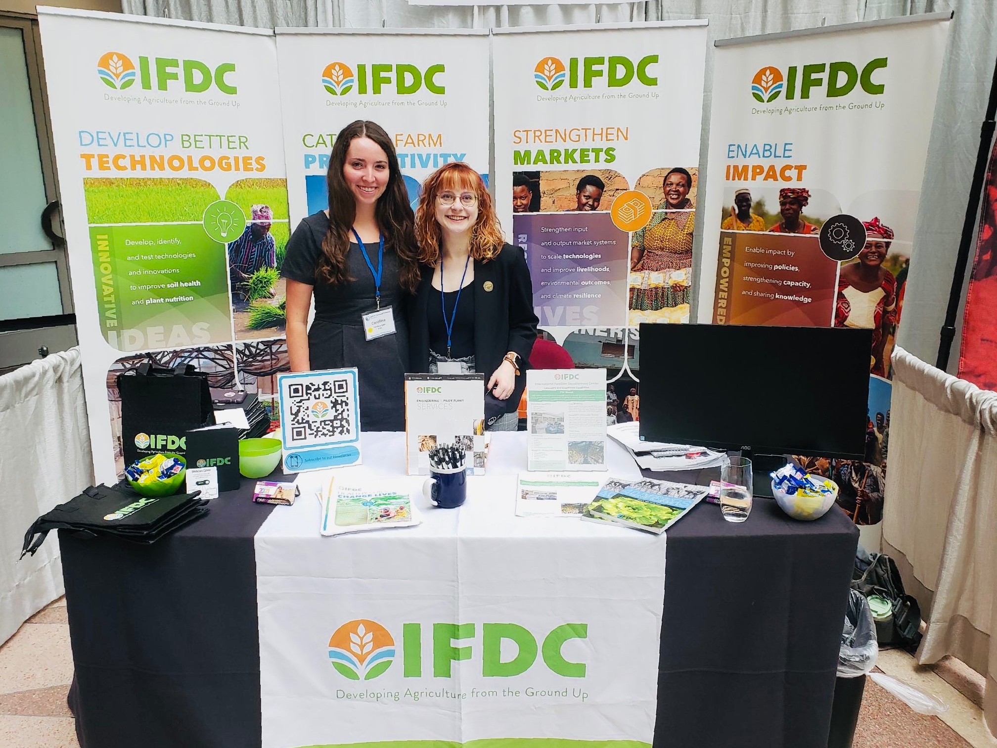 Caroline Sage & Anna Goodwin Stand at IFDC Booth for The SID-US Conference
