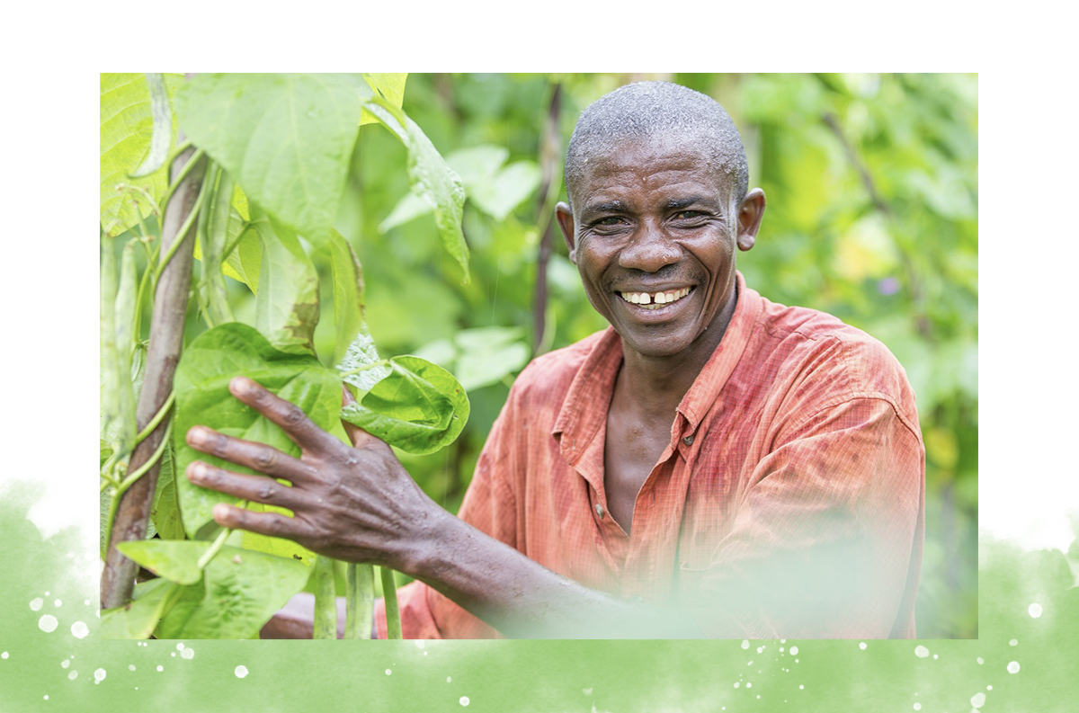 A Burundian Farmer stands next to his beans