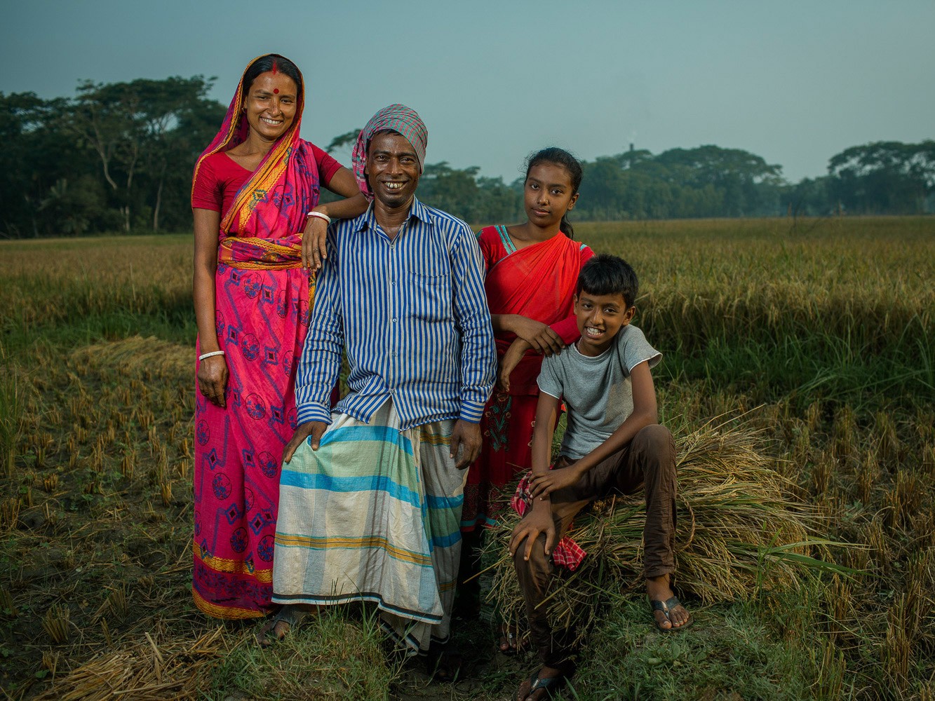 A Bangladeshi family poses in their field